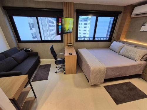 una camera da letto con un letto, un divano e finestre di Estudio Completo perto do VLT e Metrô a Rio de Janeiro