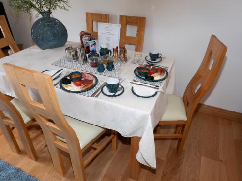 a dining table with plates of food on it at East Laigh Gree Bed and Breakfast in Burnhouse