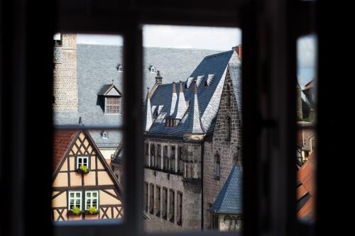 a view of an old building from a window at Hotel Theophano in Quedlinburg