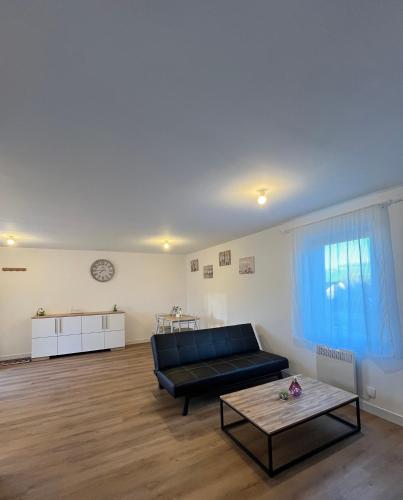 un salon avec un canapé et une table basse dans l'établissement L inattendu Le Creusot Le Breuil appartement 2 chambres proche gare tgv, à Le Breuil