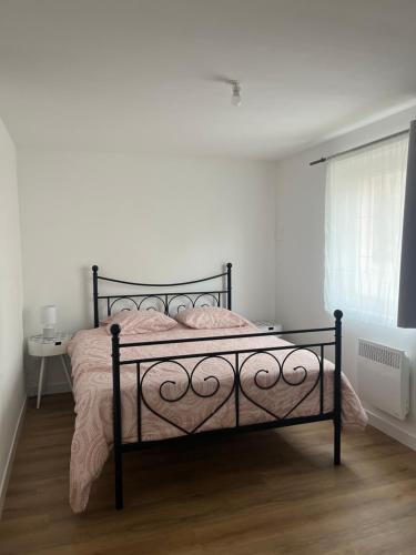 - une chambre avec un lit avec un cadre noir et une fenêtre dans l'établissement L inattendu Le Creusot Le Breuil appartement 2 chambres proche gare tgv, à Le Breuil