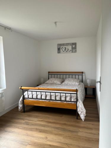 une chambre avec un lit dans une pièce blanche dans l'établissement L inattendu Le Creusot Le Breuil appartement 2 chambres proche gare tgv, à Le Breuil