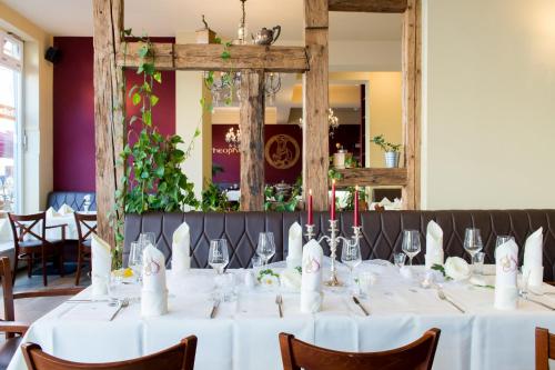 a dining room with a table with white table cloth at Hotel Theophano in Quedlinburg