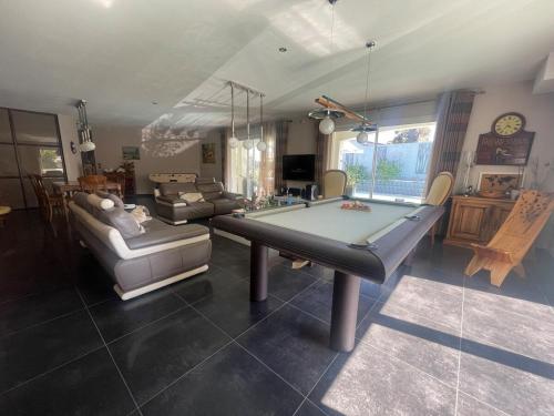 un salon avec une table de billard et un canapé dans l'établissement Villa avec piscin, proche plages et centre, à Sausset-les-Pins