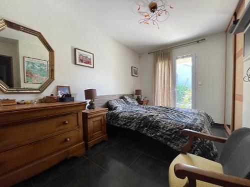 une chambre avec un lit, une commode et un miroir dans l'établissement Villa avec piscin, proche plages et centre, à Sausset-les-Pins