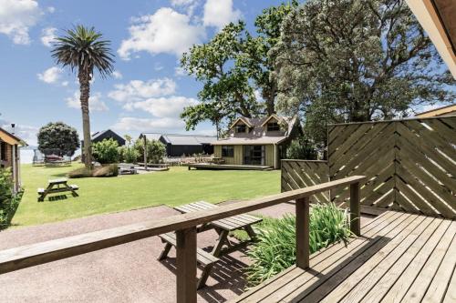 a wooden deck with a bench and a yard at Bethshan Motel in Algies Bay
