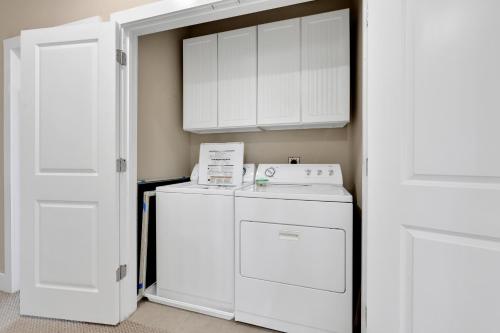 a white laundry room with a washer and dryer at Mannanan Mac Lir in Galveston