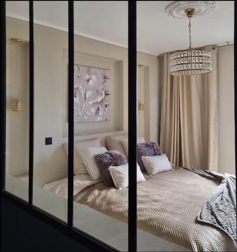 a mirror in a bedroom with a bed and a chandelier at Au bois d'Ô in Philippeville