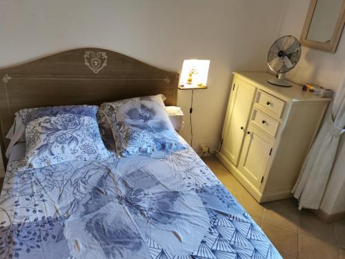 - une chambre avec un lit doté d'une couette bleue et d'un ventilateur dans l'établissement Casuccia Piazza di i Fiori, à Penta-di-Casinca