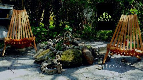 a garden with a pile of rocks and hammocks at Casa Ricky's in Orange Walk