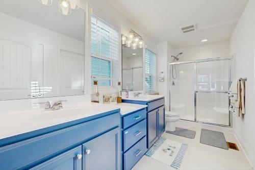 a bathroom with blue cabinets and a sink and a shower at Arbor-Lyn --- 19319 Loblolly Cir. in The Plantations