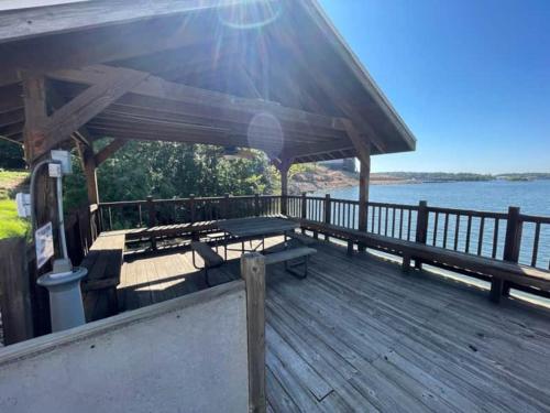 a wooden deck with a picnic table on the water at Four Seasons Luxury condo on the Lake in Lake Ozark