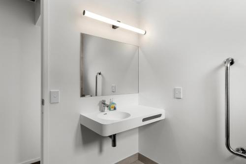 a white bathroom with a sink and a mirror at Bethshan Motel in Algies Bay