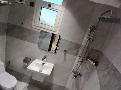 a bathroom with a sink and a toilet and a window at قمم النماص 2 Qimam alnamas in Al Namas