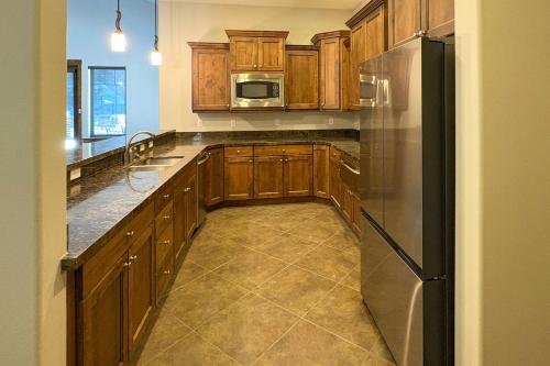a kitchen with wooden cabinets and a stainless steel refrigerator at Park City Retreat in Kamas
