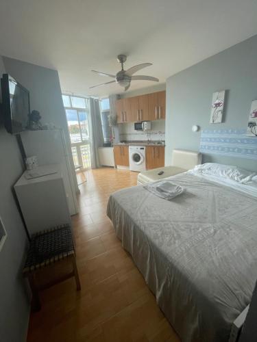 sypialnia z łóżkiem i telewizorem oraz kuchnia w obiekcie Benalmadena ,apartamento-Estudio primera Línea de Playa w mieście Benalmádena