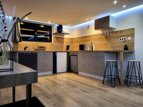 une cuisine avec un comptoir et quelques tabourets de bar dans l'établissement L'incontournable Love Room, à Peyrins