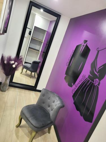 - un dressing avec une chaise et un mur violet dans l'établissement L'incontournable Love Room, à Peyrins