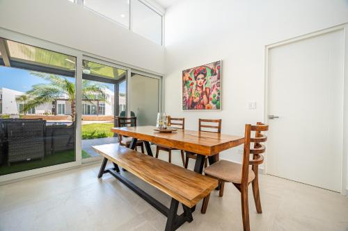 a dining room with a wooden table and a bench at The Enclave D9 in Playa Avellana