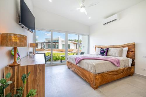 a bedroom with a bed and a flat screen tv at The Enclave D9 in Playa Avellana