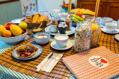 een tafel met borden en fruitschalen bij Downtown B&B in Bassano del Grappa