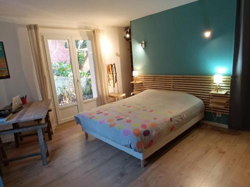 une chambre avec un lit, un bureau et une fenêtre dans l'établissement Spacieux t3 jardin et piscine, à Hyères