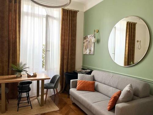 un soggiorno con un divano, un tavolo e uno specchio di Appartement PARIS avec Parking a Vanves