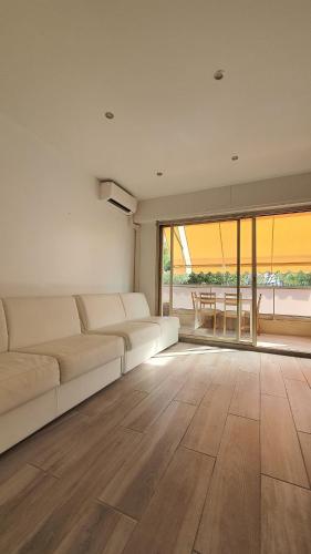 un salon avec un canapé blanc et une grande fenêtre dans l'établissement Beach Studio Cannes, à Cannes