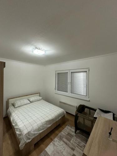 sypialnia z łóżkiem, oknem i stołem w obiekcie Apartman Tajchi w Sarajewie