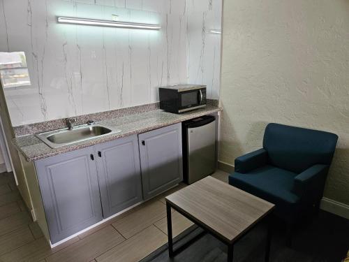 a small kitchen with a sink and a blue chair at Deluxe Inn - Sarasota in Sarasota