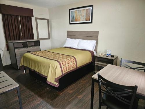 サラソタにあるDeluxe Inn - Sarasotaのベッドとテーブルのあるホテルの部屋