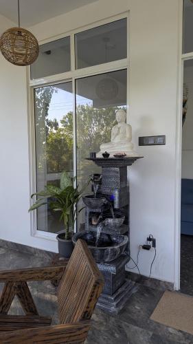 a living room with a stone fountain in front of a window at Skyy Villa matara in Matara