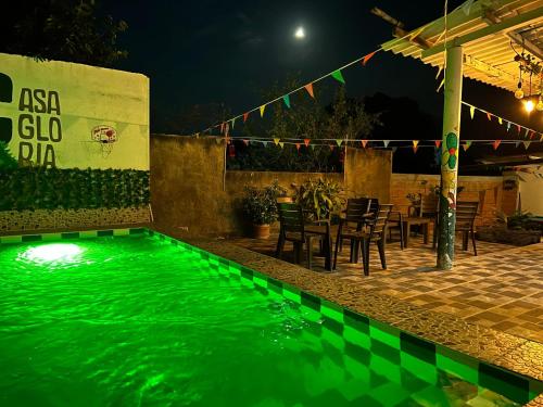 a swimming pool with green water at night at Casa Gloria Hostal in Bonda