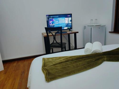 a bedroom with a bed with a computer on a desk at MayBach Hills Palace Guesthouse in Saldanha
