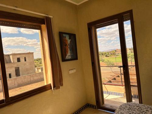 a room with two windows and a view of a building at Amlkis golf royal in Marrakech