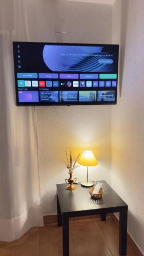 a table with a lamp and a tv on a wall at Apartment in Altura, Algarve with Balcony Near Beach and Town Center in Altura