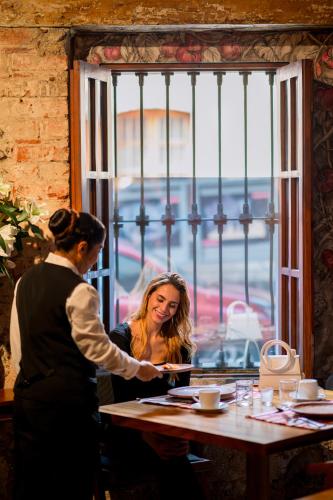 a woman is serving a woman at a table at Antiguo Molino de San Jerónimo in Mexico City