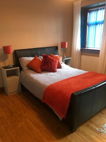 a bedroom with a large bed with red pillows at Oakbank near Thornhill in Thornhill
