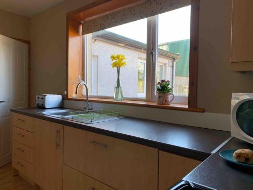 a kitchen with a sink and a window at Oakbank near Thornhill in Thornhill