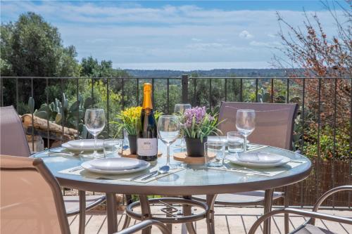 a table with glasses and a bottle of wine at Finca Agroturismo Es Pujol in Santanyi