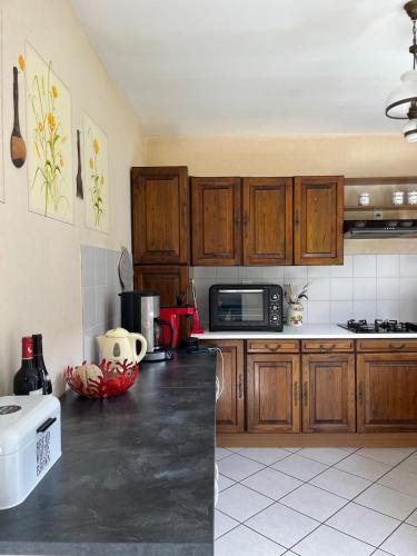 une cuisine avec des armoires en bois et un comptoir noir dans l'établissement Chalet L Etend d Art, Explore Oisans, à Allemont