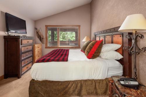 a bedroom with a large bed and a television at Lodge at Whitefish Lake in Whitefish