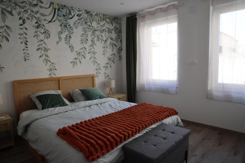 une chambre avec un grand lit avec une couverture rouge dessus dans l'établissement Le Verdoyant , maisonnette cosy avec terrasse, à Hagondange