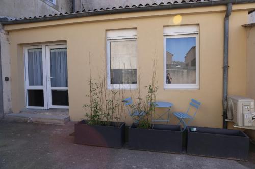 une maison avec deux chaises, une table et deux fenêtres dans l'établissement Le Verdoyant , maisonnette cosy avec terrasse, à Hagondange