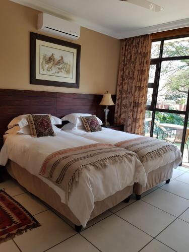 a bedroom with a large bed and a large window at Paisley & Pomegranate in Utrecht