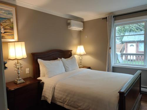 a bedroom with a bed with two lamps and a window at Semi Centre House in White Rock