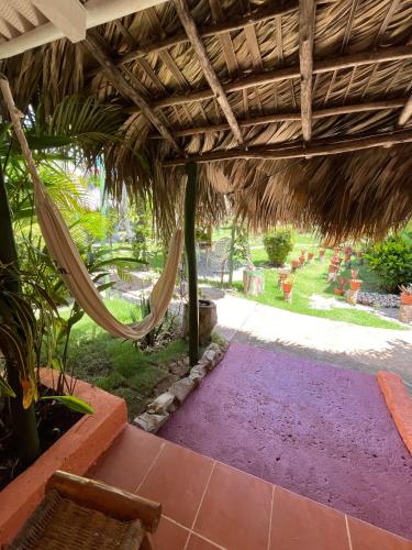 an outdoor patio with a hammock under an umbrella at Arena Oceanview Hotel & La Terraza Restaurant in Las Galeras