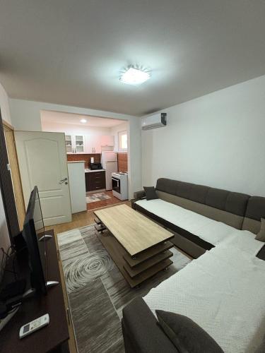 salon z kanapą i stołem w obiekcie Apartman Tajchi w Sarajewie