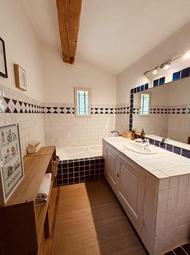 une salle de bain avec une baignoire et un lavabo dans l'établissement Havre de paix et de charme avec piscine, à Saint-Maximin-la-Sainte-Baume