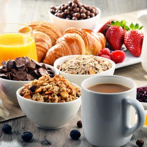 a breakfast table with croissants fruit and coffee at L'Écho des vagues in Baie-Sainte-Catherine
